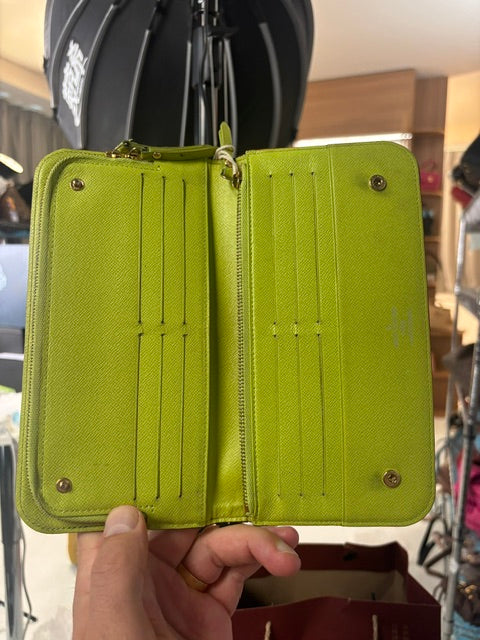Louis Vuitton Murakami long wallet open, showing lime green leather interior with card slots and zip pocket